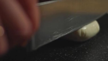 Mozzarella 'nın kesim tahtasıyla dilimlenmesi. 4K video.