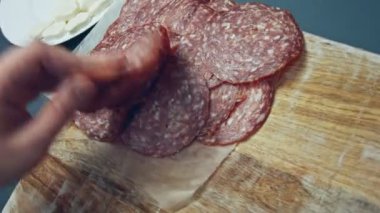 Tahta tepside dilimlenmiş İtalyan sosisi şeklinde kalp şeklinde. Sevgililer Günü için kalp şeklinde pizza hazırlıyorum. Sevdiğim biri için. 4K video.