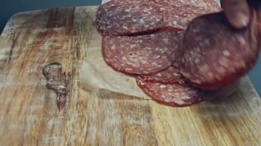 Tahta tepside dilimlenmiş İtalyan sosisi şeklinde kalp şeklinde. Sevgililer Günü için kalp şeklinde pizza hazırlıyorum. Sevdiğim biri için. 4K video.