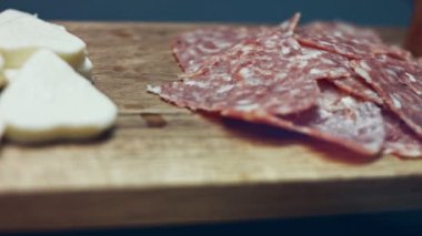 Tahta tepside dilimlenmiş İtalyan sosisi şeklinde kalp şeklinde. Sevgililer Günü için kalp şeklinde pizza hazırlıyorum. Sevdiğim biri için. 4K video.