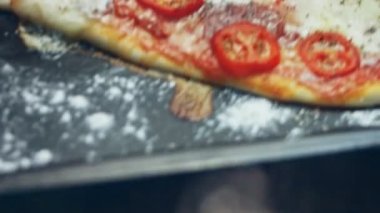 Tahtaya sıcak kalp şeklinde pizza koymak. Sevgililer Günü 'nde sevdiklerine sürpriz yemek. 4K video. Sanatsal çekim.