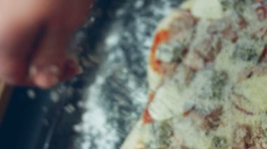 Pizzanın üzerine başka malzemelerle parmesanlı peynir serpiştirmek. Sevgililer Günü için kalp şeklinde ton balıklı pizza hazırlıyorum. 4K video.