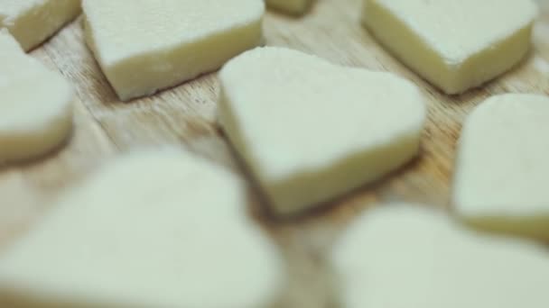 木の板にモッツァレラチーズのハート型を切る女性の手 バレンタインデーのための食べ物を準備する 4Kビデオ 芸術的撮影 — ストック動画