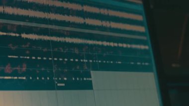 Bilgisayar ekranındaki ses dalgaları. Müzik için ses kaydı. Kayıt stüdyosu veya radyo. Zayıf ışık.