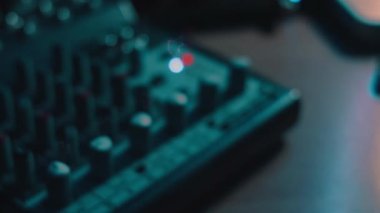 Ses karıştırma konsolunu ayarlayan parmaklar yakın plan. Ses üretimi için kayıt stüdyosunda mikser konsolu. Zayıf ışık.