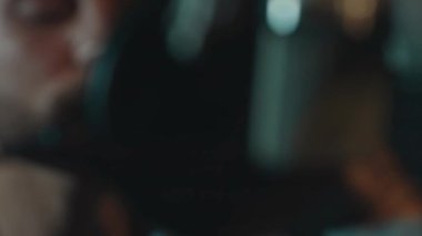 Profesyonel mikrofonlu yakışıklı rap şarkıcısının portresi modern stüdyoda şarkı söylüyor. Müzik prodüksiyonu. Zayıf ışık.