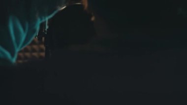 Profesyonel mikrofonlu yakışıklı rap şarkıcısının portresi modern stüdyoda şarkı söylüyor. Müzik prodüksiyonu. Zayıf ışık.