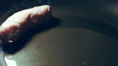 Siyah tavada yağlı sosis pişirin. Sıcak ayçiçeği yağında kızarmış sosis.