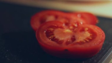 Kadın eli mutfak bıçağıyla kesme tahtasında taze domates kesiyor. Sağlıklı beslenme