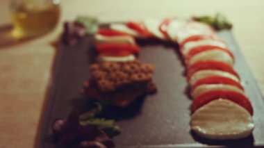 Caprese - İtalyan ulusal yemeği. Noel şeker kamışı şeklinde dilimlenmiş domates ve mozarella. Fesleğen ve zeytinyağıyla servis edilir. Yavaş çekim.