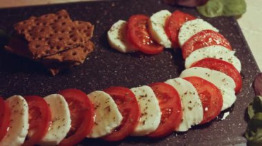 Caprese - İtalyan ulusal yemeği. Noel şeker kamışı şeklinde dilimlenmiş domates ve mozarella. Fesleğen ve zeytinyağıyla servis edilir. Yavaş çekim.