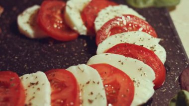 Caprese - İtalyan ulusal yemeği. Noel şeker kamışı şeklinde dilimlenmiş domates ve mozarella. Fesleğen ve zeytinyağıyla servis edilir. Yavaş çekim.