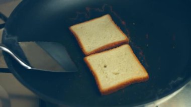 Kızartma tavasında dilimlenmiş ekmek pişirmek. Şef döner ve kızarmış tavada taze ekmek kızartır.