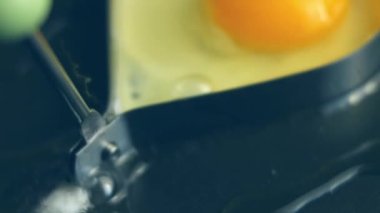 Tavada kalp şeklindeki bir yumurtayı kır. İştah açıcı görünmek için yeni yemek menüleri oluşturun. Yiyecek konsepti.