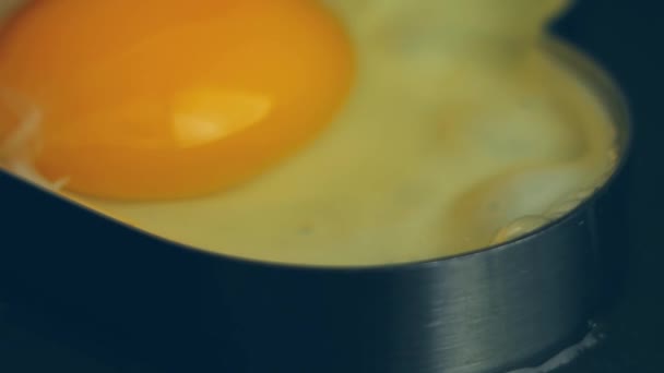 鍋にハート型の型に卵をクラック 食欲をそそる新しい食品メニューを作成します 食のコンセプト — ストック動画
