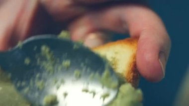 Sağlıklı vegan avokado tostu hazırlıyorum. Çavdar ekmeğine yapışmış avokado ezmesi, yakın çekim.