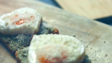 Kırık avokado ve ahşap bir tahtanın üzerinde parmesanlı peynirli tost ekmeği üzerinde kalp şeklinde yumurtalar. 8 Mart 'ta sürpriz kahvaltı hazırlıyorum. Makro görünüm, yavaş çekim