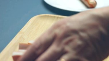 Et sosislerini bıçakla kesmek, sosisleri seramik bıçakla kesmek, Şef sosisleri pişirme bıçağıyla kesiyor, sosisleri yakın plan dilimliyor.