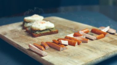 Kırık avokado ve ahşap bir tahtanın üzerinde parmesanlı peynirli tost ekmeği üzerinde kalp şeklinde yumurtalar. 8 Mart 'ta sürpriz kahvaltı hazırlıyorum. Makro görünüm, yavaş çekim
