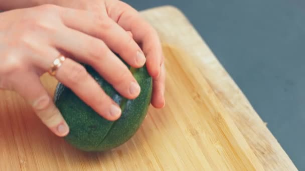 Chef Black Gloves Peels Cuts Avocado Wooden Table — Stock Video