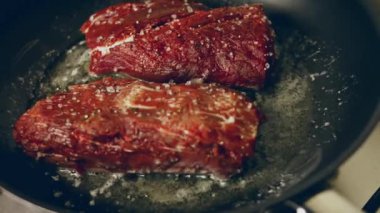 Diğer et ve sosislerle çevrili ızgarada biberiyeyle fırçalanmış sulu biftek bifteği. yavaş çekim