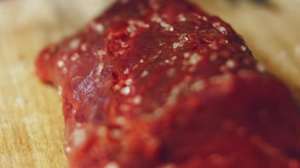 厨师在生肉上撒盐 厨师在厨房的专业餐桌上用4千种蔬菜制作肉类 — 图库视频影像