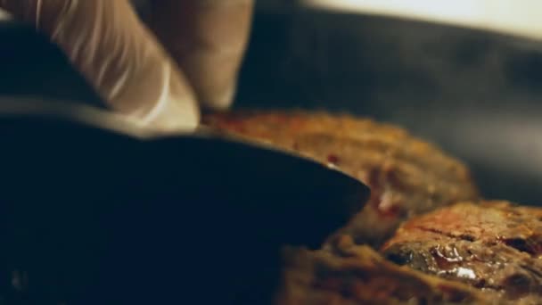 他の肉やソーセージに囲まれた炎のグリルでローズマリーでブラッシュアップジューシーなステーキ肉の牛肉を調理 スローモーション — ストック動画
