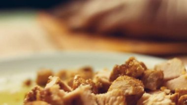 Kadın kızarmış tavuk göğsünü tahtadan dilimlere ayırıyor.