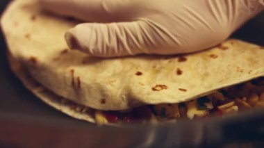 Kızartma tavasında taze sarılmış tavuk quesadilla kızartıyorum. Örtüyü çıkarıyorum. Meksika usulü quesadillas yapma süreci