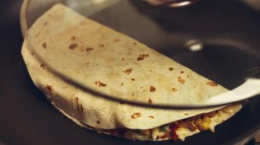 Kızartma tavasında taze sarılmış tavuk quesadilla kızartıyorum. Örtüyü çıkarıyorum. Meksika usulü quesadillas yapma süreci