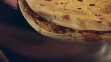 Kızartma tavasında taze sarılmış tavuk quesadilla kızartıyorum. Örtüyü çıkarıyorum. Meksika usulü quesadillas yapma süreci
