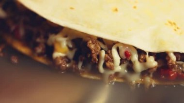 Kızartma tavasında taze sarılmış tavuk quesadilla kızartıyorum. Örtüyü çıkarıyorum. Meksika usulü quesadillas yapma süreci