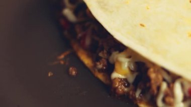 Kızartma tavasında taze sarılmış tavuk quesadilla kızartıyorum. Örtüyü çıkarıyorum. Meksika usulü quesadillas yapma süreci