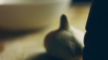 Sarımsaklar masanın üzerinde duran cam bir kaseye düşer.