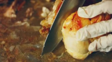 Aşçı haşlanmış tavuk, yavaş çekimde yakın çekim. Yakın plan eller haşlanmış tavuk bacağı. Yakın plan eller mutfakta haşlanmış tavuk bacağı kesiyor..