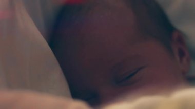 bebeklik, çocukluk, gelişme, tıp ve sağlık konsepti - yeni doğmuş, çıplak, uyuyan bir bebeğin yüzü. Yüzünde bandaj ve kafasında pembe bir çiçek var..