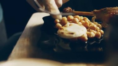 Ördek eti ve nohut ve pişmiş sebze tadı alıyorum ördek buhar yapıyor ve çok iştah açıcı görünüyor.