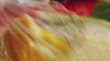 Taze yumurta, un ve sütü cam bir kasede çelik elle karıştırmanın makro görüntüsü. Krep hazırlama süreci. 4K video