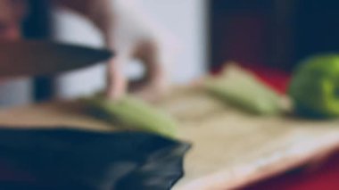 Şef, kereviz sebzesini tahta kesme tahtasıyla keser. Ellerinizi kapatın. 4k sinematografi tarifi.