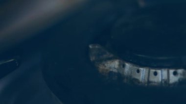 Siyah arka planda fırın ocağını açıyorum. Mutfak ocağı açılıyor. Ateşe yaklaş. Soba ocağında doğal gaz iltihabı, yakın görüş. Mutfak gaz sobasından gaz yanıyor..