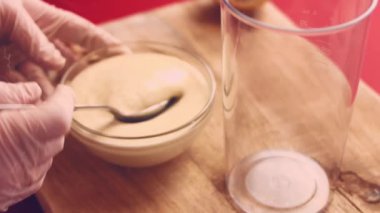 Bir mayonez sıvısının kabın içine akışını yakından çek. Plastik spatula kullanarak mayonez sıvısını yaymak. Depo kutusuna bir sürü mayonez sıvısı döküyorum. Gıda Üretimi.