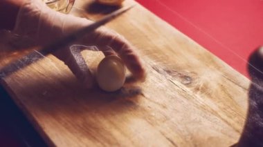 Ahşap bir tahtanın üzerinde bıçakla haşlanmış yumurtaları halkalara ayır. Adım adım altın para yumurta tarifi.