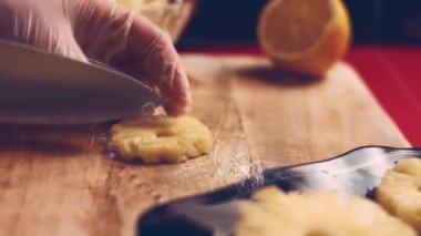 Kadın elleri taze olgun ananas meyvesi keser ve sağlıklı kahvaltı içeceği yapmak için evdeki mutfakta kaseye koyar. ev yemeği