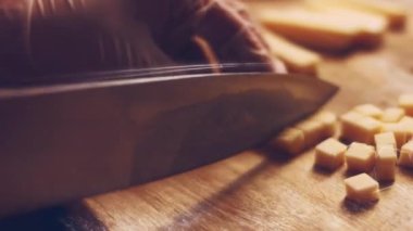 Peyniri çok doğru ve nazikçe dilimliyor. Peynir kesmek için mükemmel bir yol. Güzel kahvaltı. Güneşli hafif tabaklar. Peynir kesmek için keskin bıçak. Yumuşak sarı peynir kübü yemekten zevk alıyorum.