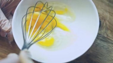 Sabah omleti ya da çırpılmış yumurta için çırpılmış yumurtaları metal kâsede çırpın. Fırında hamur hazırlamak için yumurta çırpıyorum. Kahvaltı hazırlama kavramı.