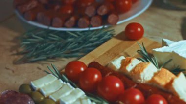 Peynir ve domates düzlüğü. Noel ağacı şeklinde dizilmiş peynir, domates ve rozmarin dilimleri. Noel tatili için yemek. Döndürme. Yavaş çekim.