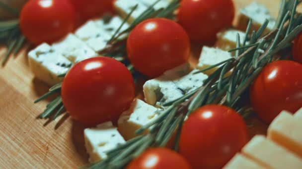 チーズとトマトの平置き チーズ トマト ロズマリンのスライスがクリスマスツリーの形で配置されています クリスマス休暇のための食品 回転だ スローモーション — ストック動画