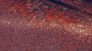 Rusty painted metal surface. Macro view of corrosion in iron metal, texture background. Smooth slow motion.