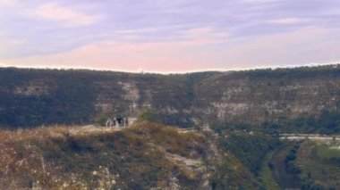 Alp dağlarının hava görüntüsü. Dağlar, tepeler, uçurumlar, kayalar, çıkıntılar, manzaralar, yeşil çimenler, gökyüzü bulutları doğanın işlenmemiş insansız hava aracı videosu.