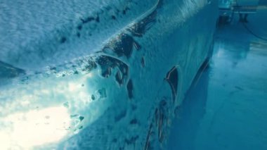 Dokunulmaz bir oto yıkamada lüks araba yıkamak. Köpüklü ve yüksek basınçlı su basınçlı sedan araba yıkıyorum. Araba yıkamada bahar temizliği..